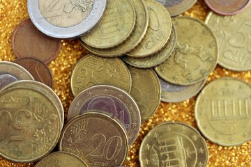 Big amount of euro coins on golden glitter background