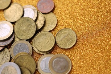 Big amount of euro coins on golden glitter background