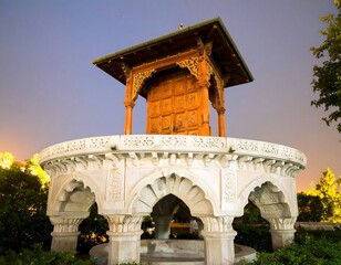 Fototapeta premium Ornate wooden structure on a stone platform at twilight