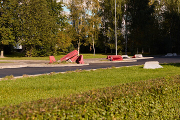 There are damaged traffic barriers on an abandoned roadway that has been left to nature