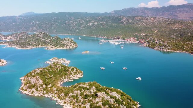 aerial footage showcases the historic Simena Castle Kalek&ouml;y overlooking the stunning turquoise waters of Kekova Bay in Antalya, Turkey.