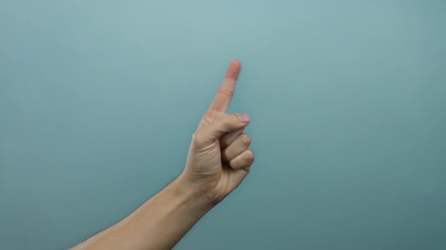 Caucasian man's hand snapping fingers against a blue background, isolated and over a simple wall, expressing gesture communication.