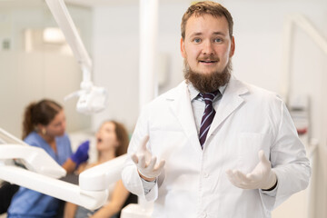 Obraz premium Male dentist invites you to visit the dental clinic