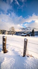 Snowy landscape with a wooden fence and mountains