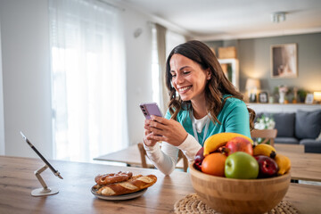 Young woman smiling using smartphone at home