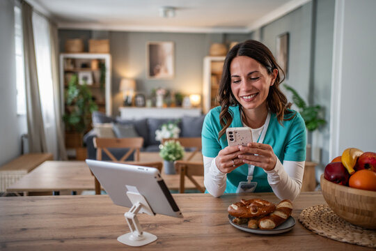 Smiling female nurse taking a break using phone