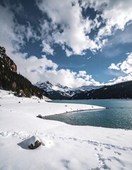 Snowy mountain lake under a dramatic sky