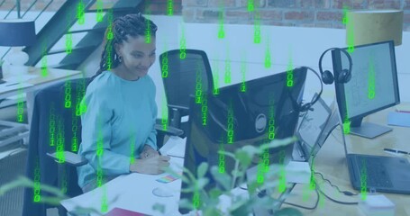 graphic designer woman at desk initiating code overlay as typing, comparing swatches, noting colors - Powered by Adobe