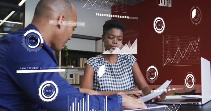 man sliding report, woman tapping charts, revealing data overlays during business meeting