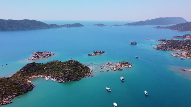aerial drone footage showcasing the historic Simena Castle Kalek&ouml;y overlooking the turquoise waters and scattered islands of Kekova Bay, Turkey, including glimpses of the ancient sunken city ruins. Th