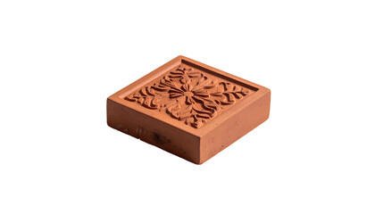 Square terracotta tile with floral relief. Isolated against a black background