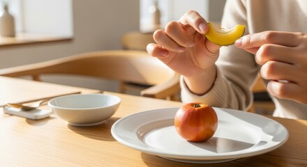 Person squeezing fresh lemon juice over ripe pomegranate on white ceramic plate in bright modern kitchen setting with natural sunlight and wooden table