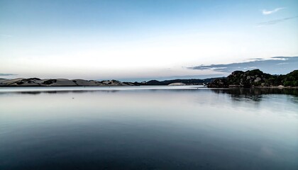 Fototapeta premium Calm water reflecting a tranquil coastal scene