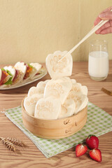 Adorable Bear Paw Shaped Bread Rolls in Bamboo Steamer with Chopsticks and Milk Glass on Wooden Table