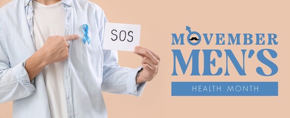 Young man holding paper with word SOS and blue ribbon on beige background, closeup. Movember -...