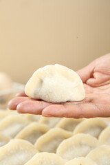 Traditional Handmade Dumpling Being Held in Hands During Food Preparation Process