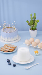 White Birthday Cake with Milk and Fresh Ingredients on Blue Background - Celebration Food Styling