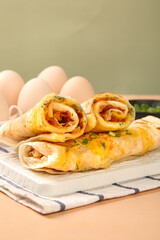 Handmade Breakfast Pancake Rolls with Ham and Eggs on Kitchen Towel