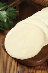 Raw White Dough Slices on Wood Board for Making Chinese Buns and Dumplings