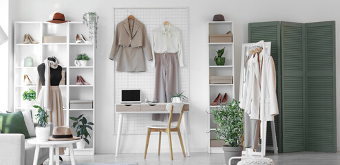 Interior of clothing store office with workplace, mannequin and shelf units