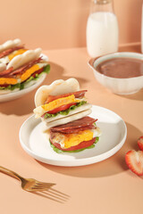 Bear Paw Shaped Breakfast Sandwich with Bacon Egg and Coffee on Pink Background