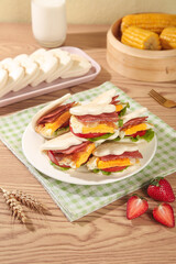 Breakfast Sandwiches with Bacon Egg and Cheese Wrapped in Bread on Wooden Table Morning Meal