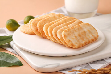 Crispy Rice Cake Slices with Fresh Limes and Milk Glass on White Plate