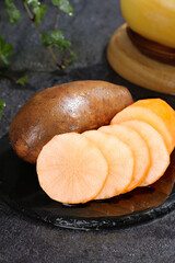 Yunnan Plateau Yellow Hearted Potato Slices on Slate Surface with Wooden Bowls