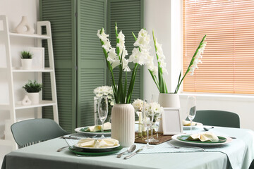 Table setting with white Gladiolus flowers in room