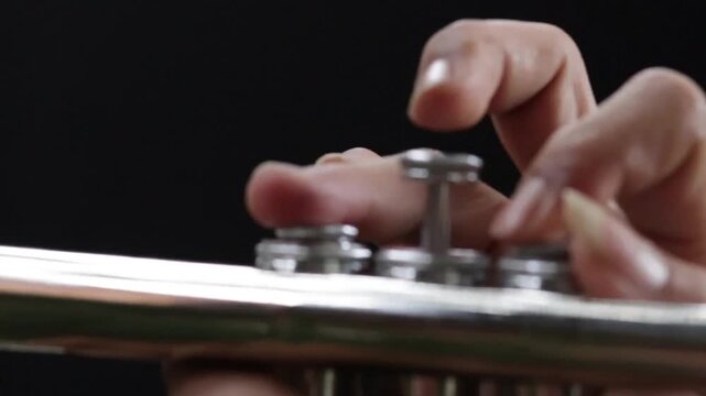 Detailed close-up of a trumpet player&rsquo;s hands pressing valves, symbolizing passion, music, and performance.
