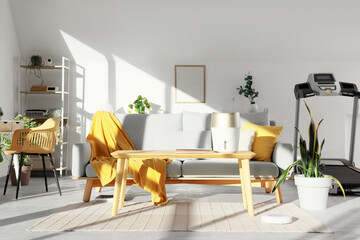 Interior of light living room with sofa, plants and appliances