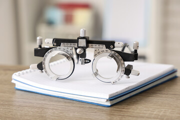Ophthalmic trial frame with notebook on medical student's table in clinic, closeup