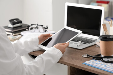 Female medical student with tablet computer at table in clinic, closeup