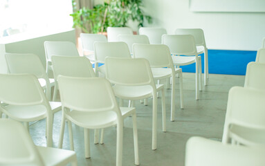 empty conference room with white chairs and a screen for backdrop