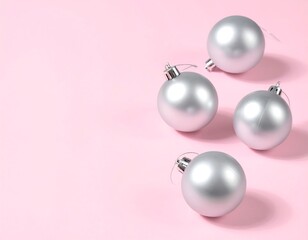 Four silver Christmas balls on a pink background