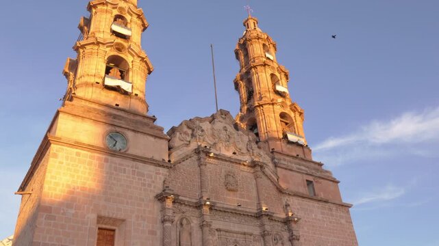 View of the Cathedral Basilica of Our Lady of the Assumption in Aguascalientes, Mexico, at sunrise with doves flying in the sky. 4k Video