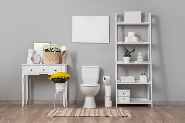 Interior of restroom with toilet bowl, shelf unit and table