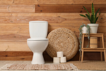 Interior of restroom with toilet bowl, plants and stool