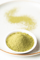 Matcha green tea powder in bowl on plate