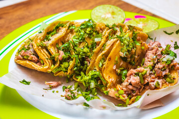 Suadero tacos with cilantro on a plate with lemons, typical Mexican food