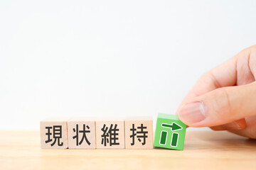 現状維持を示す木製ブロックとグラフ