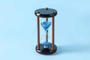 Stylish hourglass on blue background