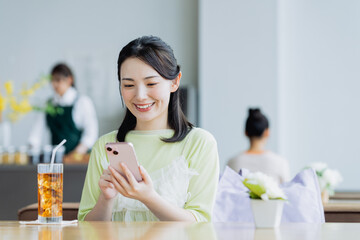 カフェでスマホを見る若い女性