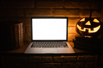 Laptop with a blank white screen mockup with space for text on a wooden shelving in evening dark...