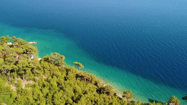 aerial perspective showcasing the stunning turquoise waters and lush green coastline surrounding the ancient city of Knidos on the Datca Peninsula in Turkey.