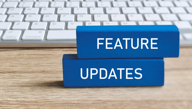 FEATURE UPDATES Text on Blue Blocks with Computer Keyboard Background for Software or Product Development