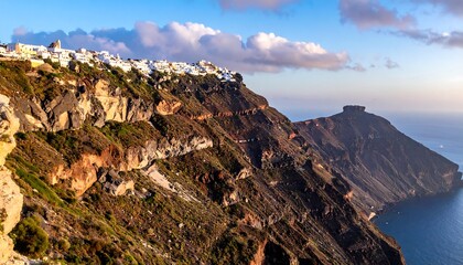 An aerial view showcasing a cliffside town with white buildings, overlooking the vast blue ocean. Golden sunlight bathes the scene