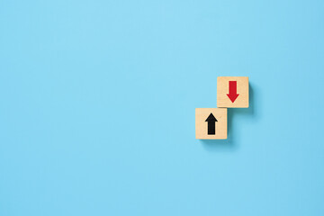 Up and down turn arrow on wooden blocks difference direction to earn or to loss. Red arrow as positive and black as negative movement idea.