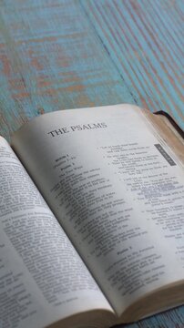 Opening to the book of Psalms of the old testament, Holy Bible. New Revised Standard Version. Vertical video format.