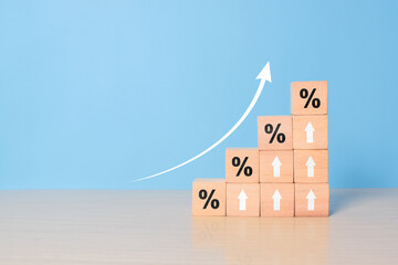 Interest rate financial and mortgage rates concept. Wooden blocks with Icon percentage symbol and arrow pointing up. The economy is improving.